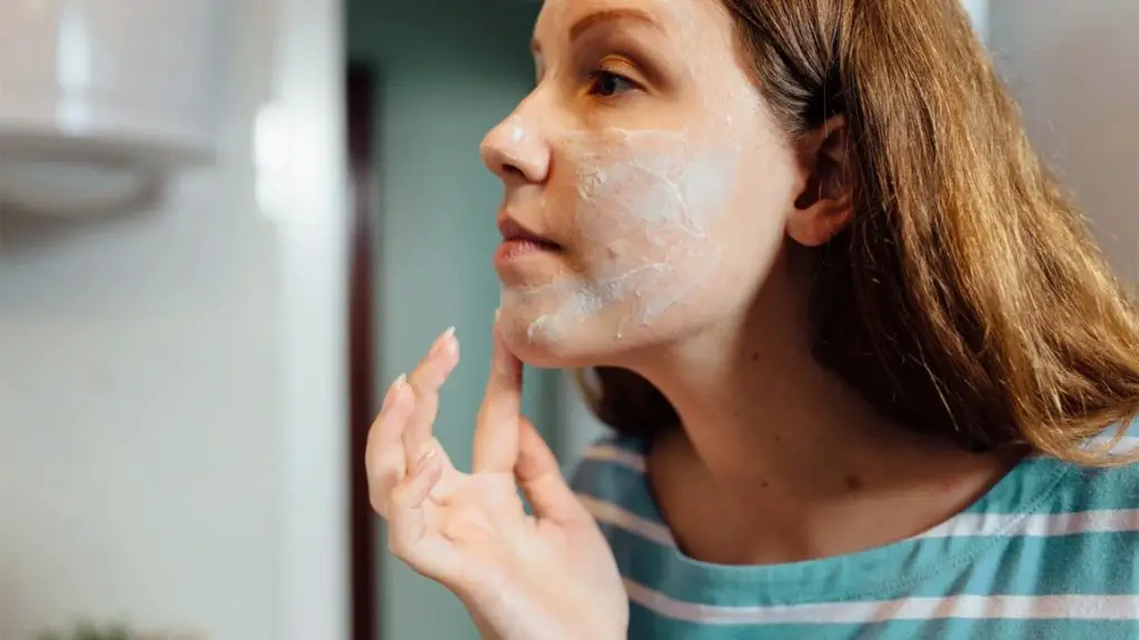 woman applying acne cream to her face